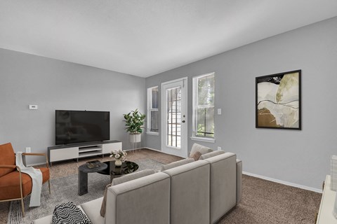 A living room with a grey couch, a black television, and a painting on the wall.