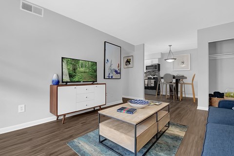 A living room with a wooden coffee table and a television on a cabinet.