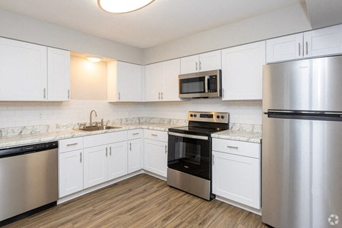 A kitchen with white cabinets and stainless steel appliances.