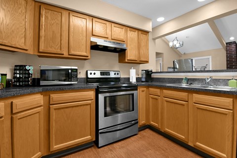 A kitchen with wooden cabinets and a black countertop.