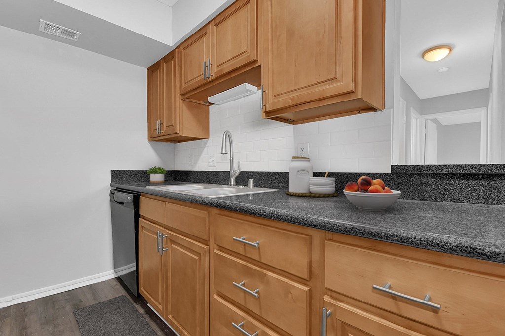 a kitchen with wood cabinets and granite counter tops and a sink
