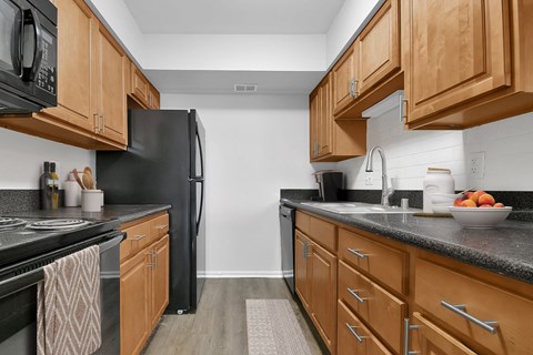 a kitchen with black appliances and wooden cabinets