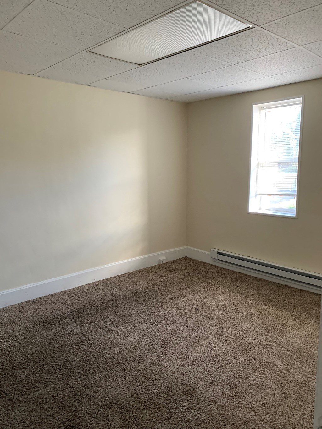 an empty room with carpet and a window