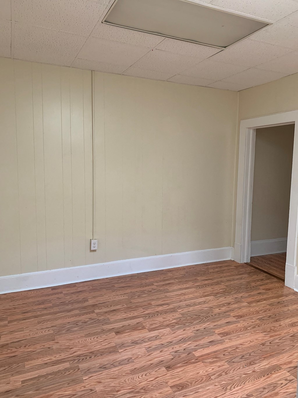 an empty living room with wood floors and white walls