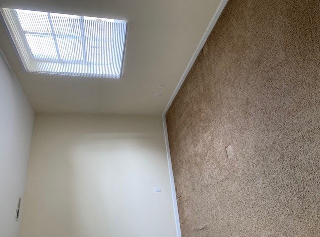 an empty room with a window in the ceiling