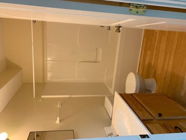 a white bathroom with a toilet and a shower
