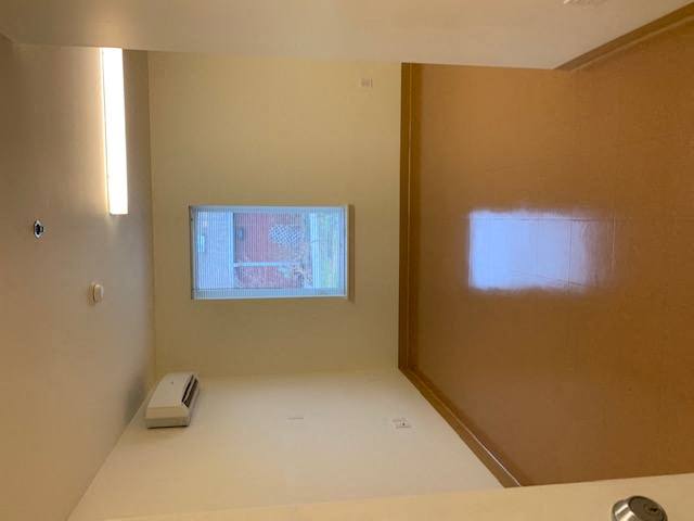 an empty bathroom with a window in the wall