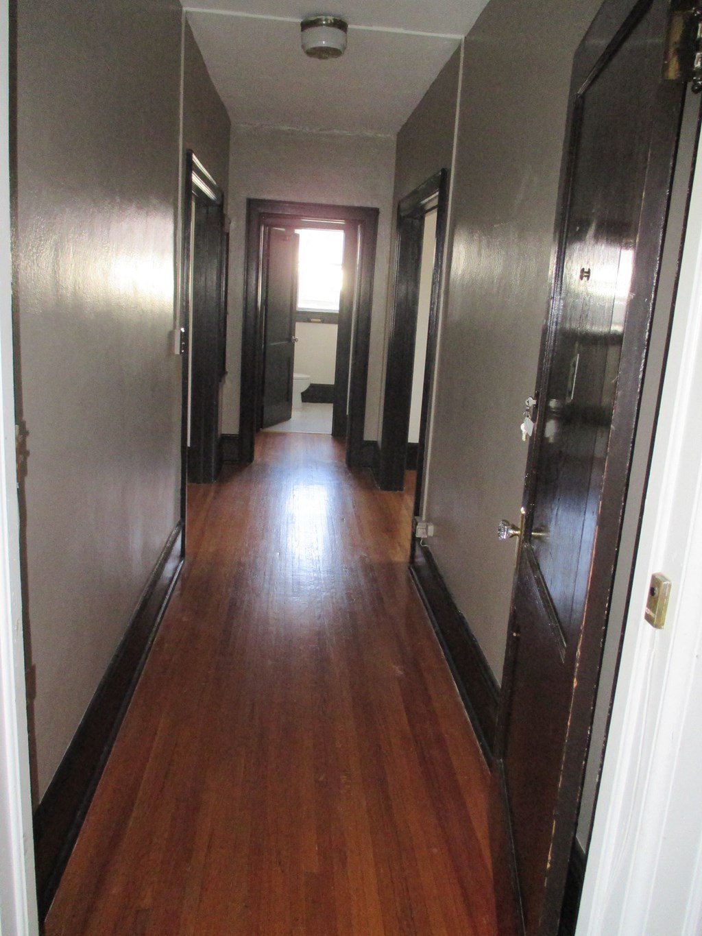 a long hallway with wooden floors and metal doors