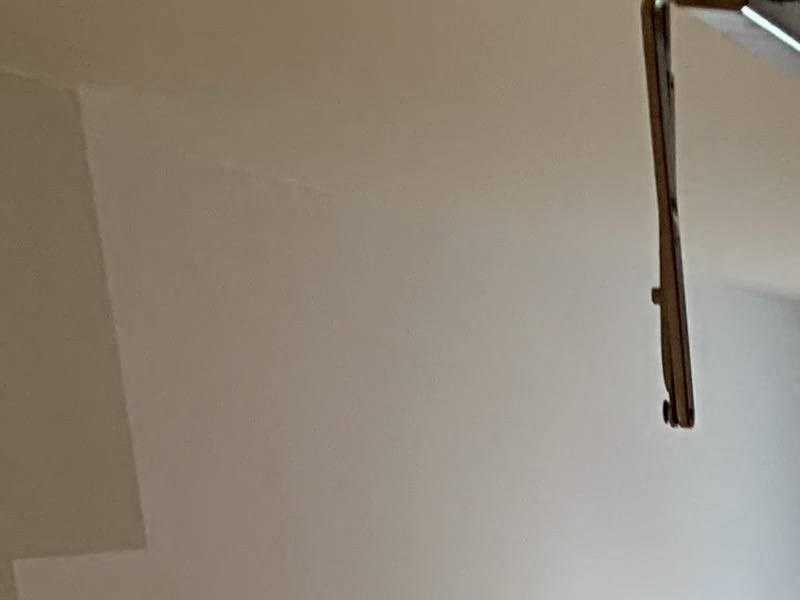 an empty room with a window and a wooden wall