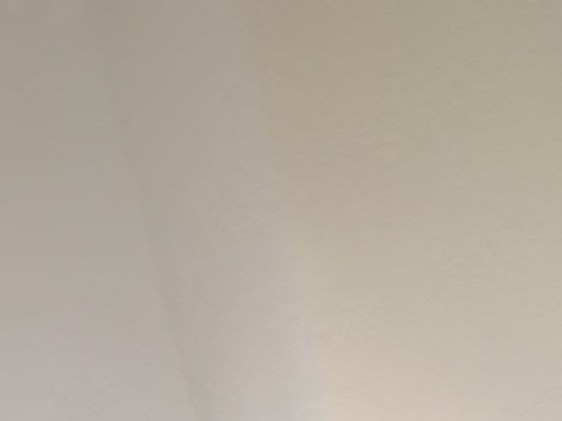 a window on the ceiling of a room with wooden flooring and a wall with
