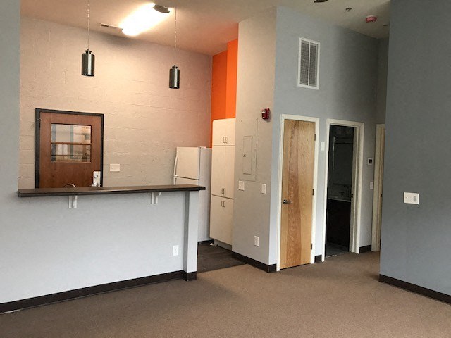 a room with a counter and a refrigerator and a door