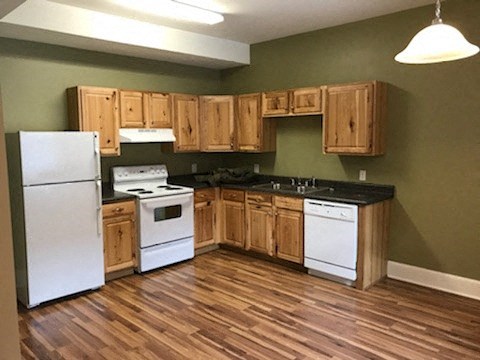 a kitchen with white appliances and wooden cabinets