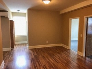 an empty living room with a hard wood floor