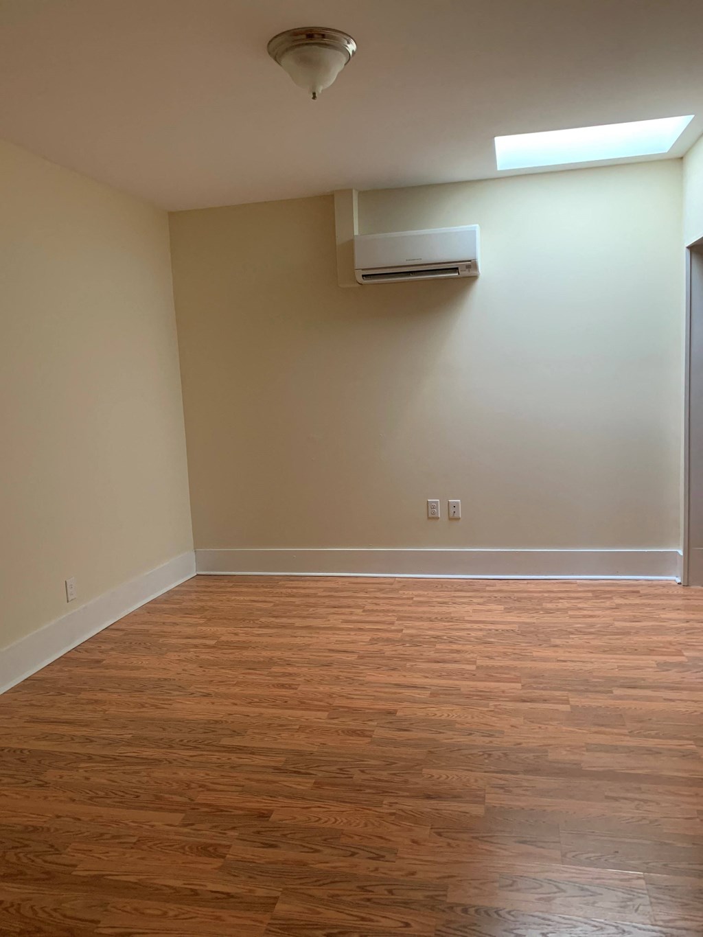 an empty room with wooden floors and a white wall