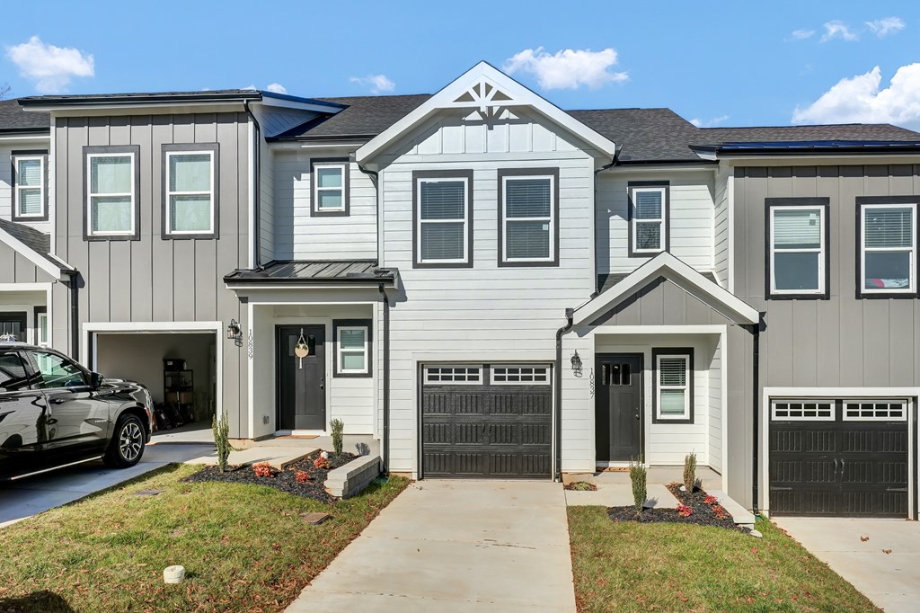 an apartment building with a driveway and a car parked in front of it