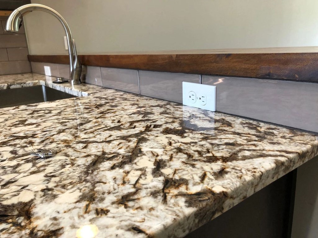 a kitchen counter top with a sink and a faucet