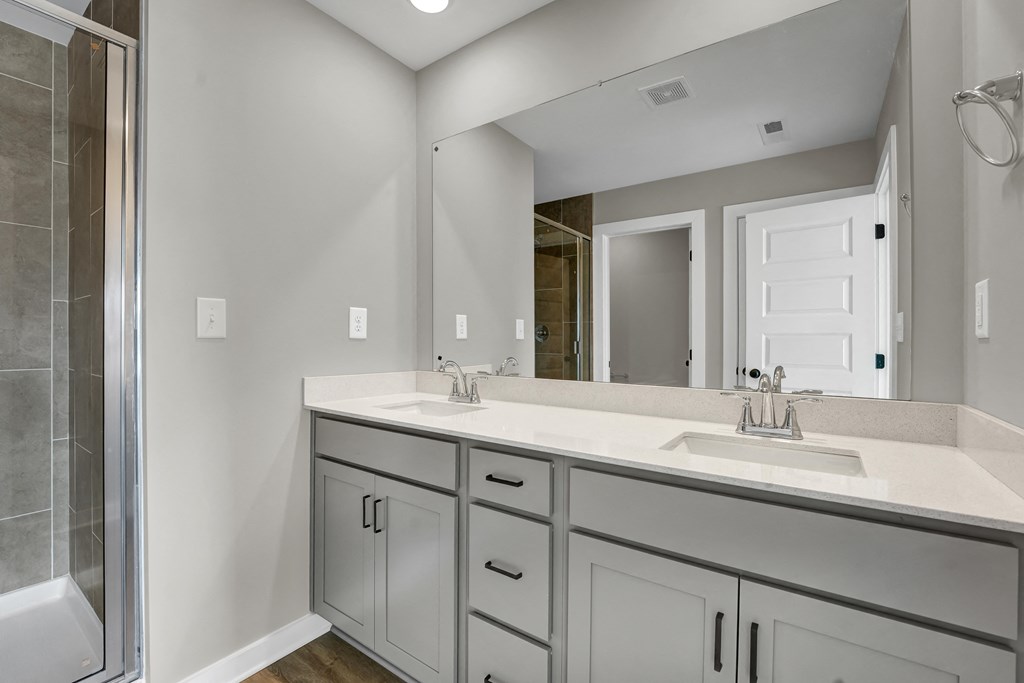 a bathroom with two sinks and a shower and a mirror