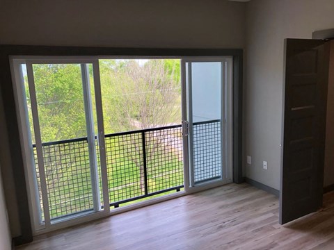 a living room with a sliding glass door overlooking a balcony