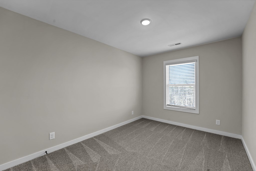 an empty room with white walls and a window