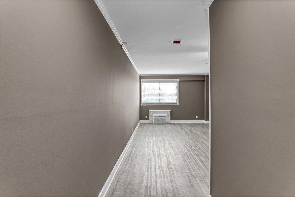 an empty room with wood floors and a window