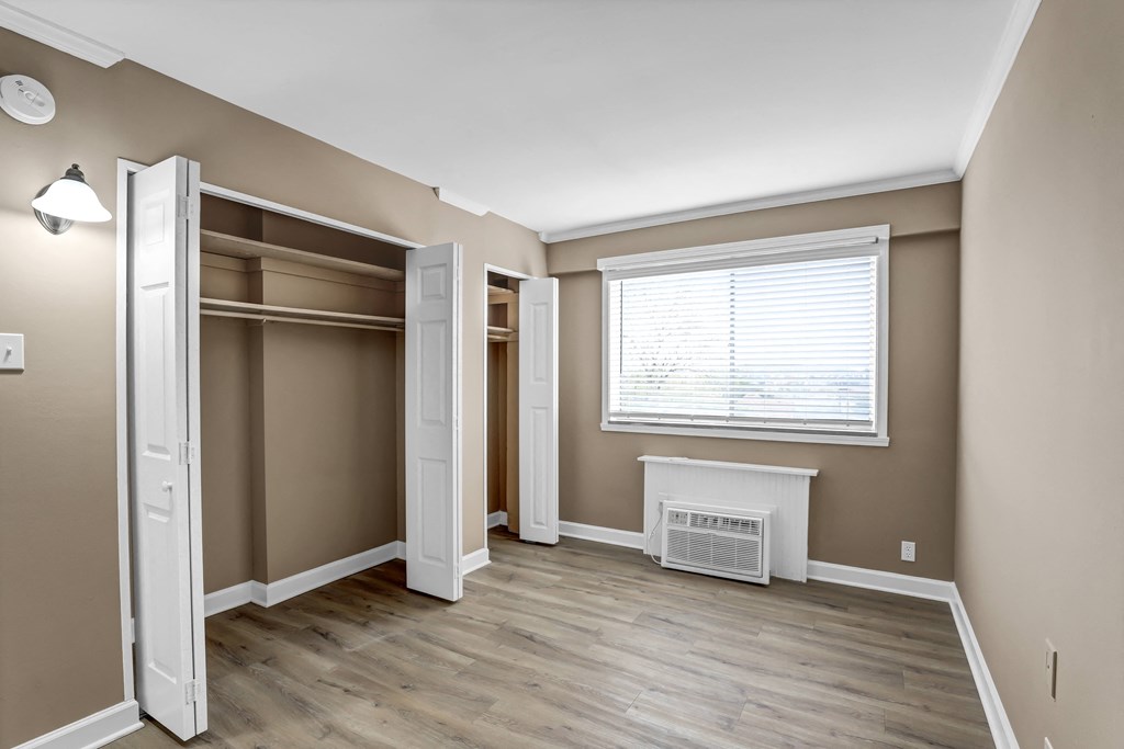 an empty bedroom with a closet and a window