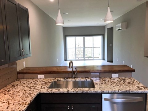 a kitchen with granite counter tops and a sink and a window