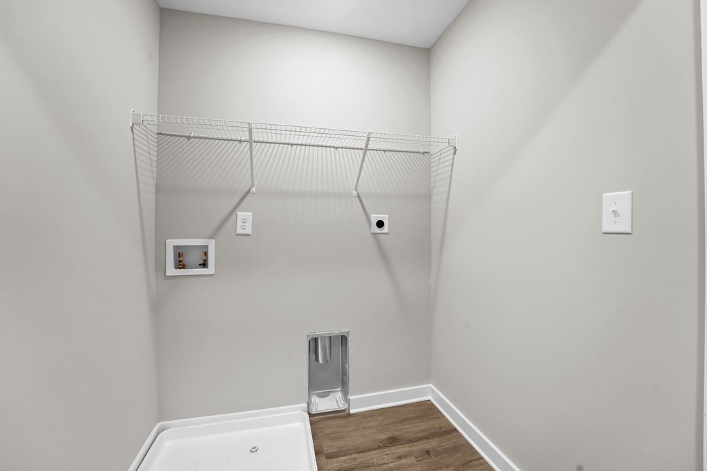 a white bathroom with a tub and a shelf on the wall