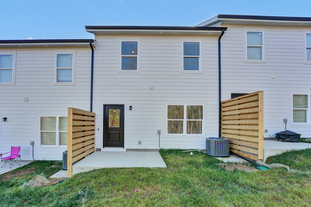 the front of a white house with a wooden fence