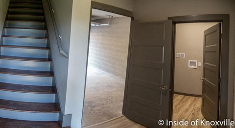 a hallway with a staircase and an open door