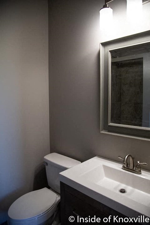 a bathroom with a toilet and a sink and a mirror