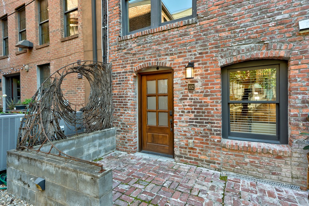 A brick building with a wooden door and a window.