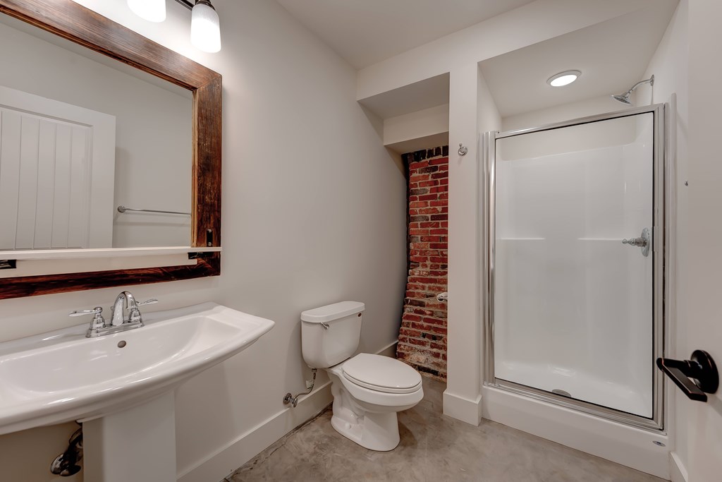 A bathroom with a toilet, sink, and shower.
