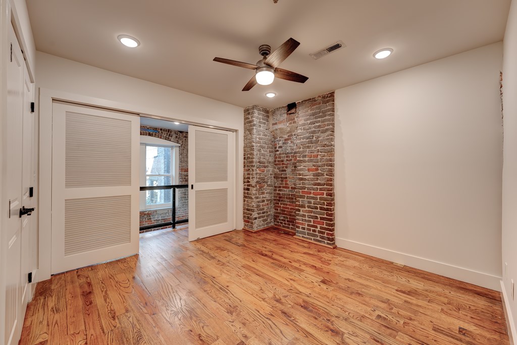 A room with wooden floors and a ceiling fan.