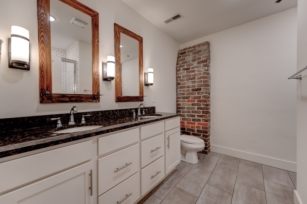 A bathroom with a brick wall and a toilet.