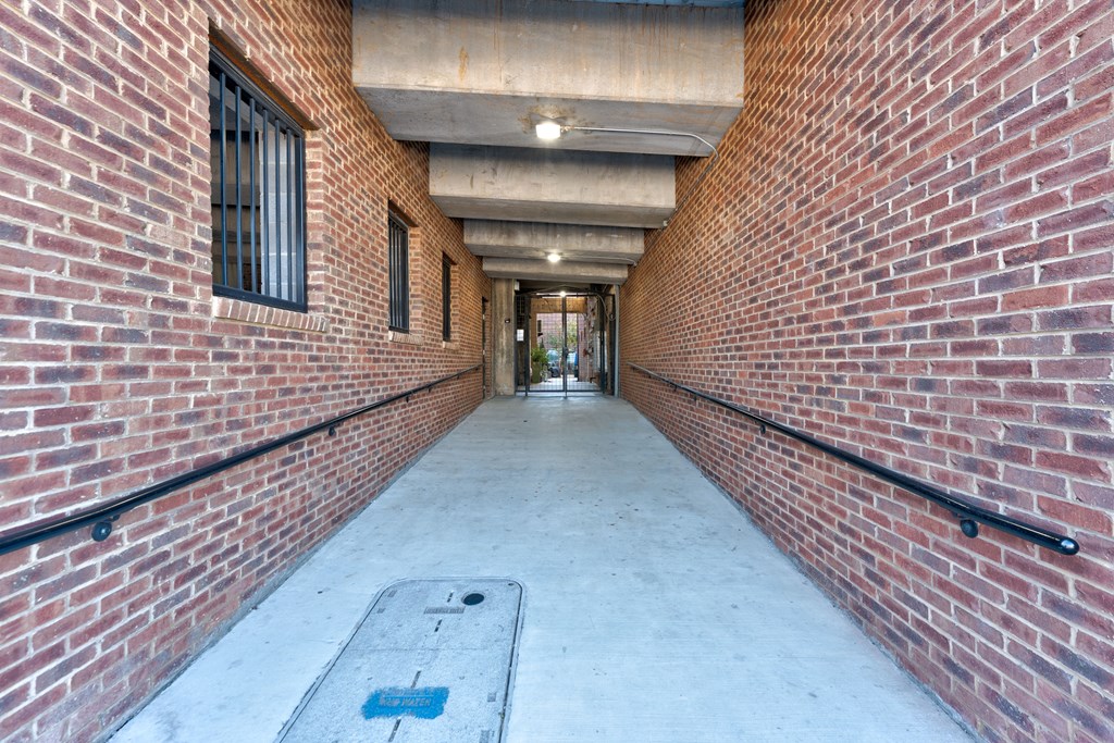 A long corridor with brick walls and a concrete floor.