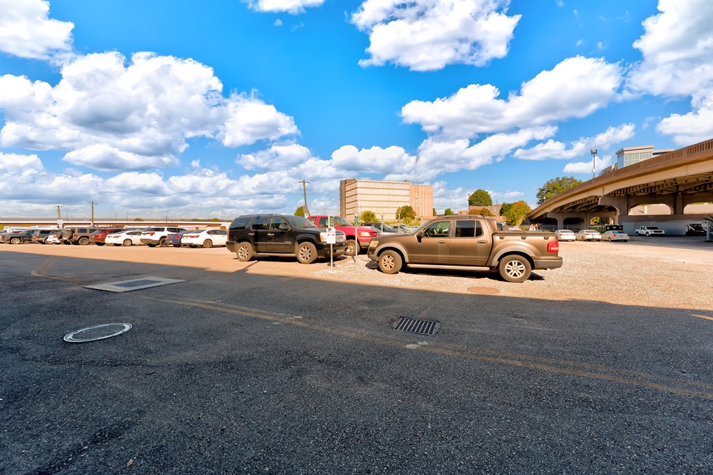 A parking lot with cars and a building in the background.