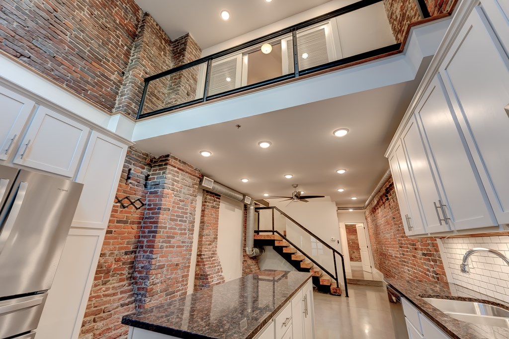 A kitchen with a staircase leading to the upper floor.