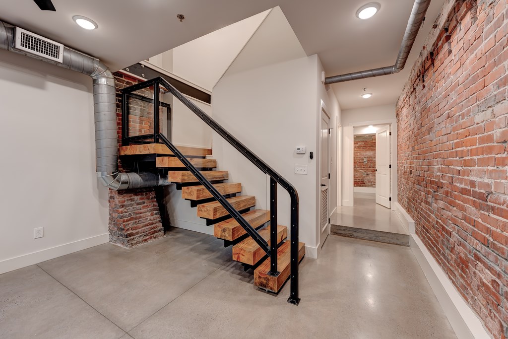 A staircase with a metal railing and wooden steps leads up to a second floor.