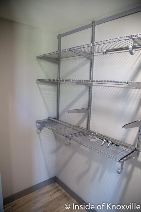 an empty closet with empty shelves on the wall