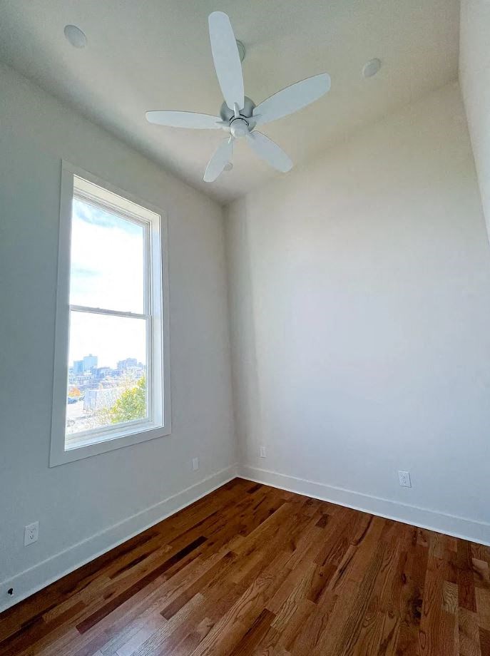 an empty room with a ceiling fan and a window