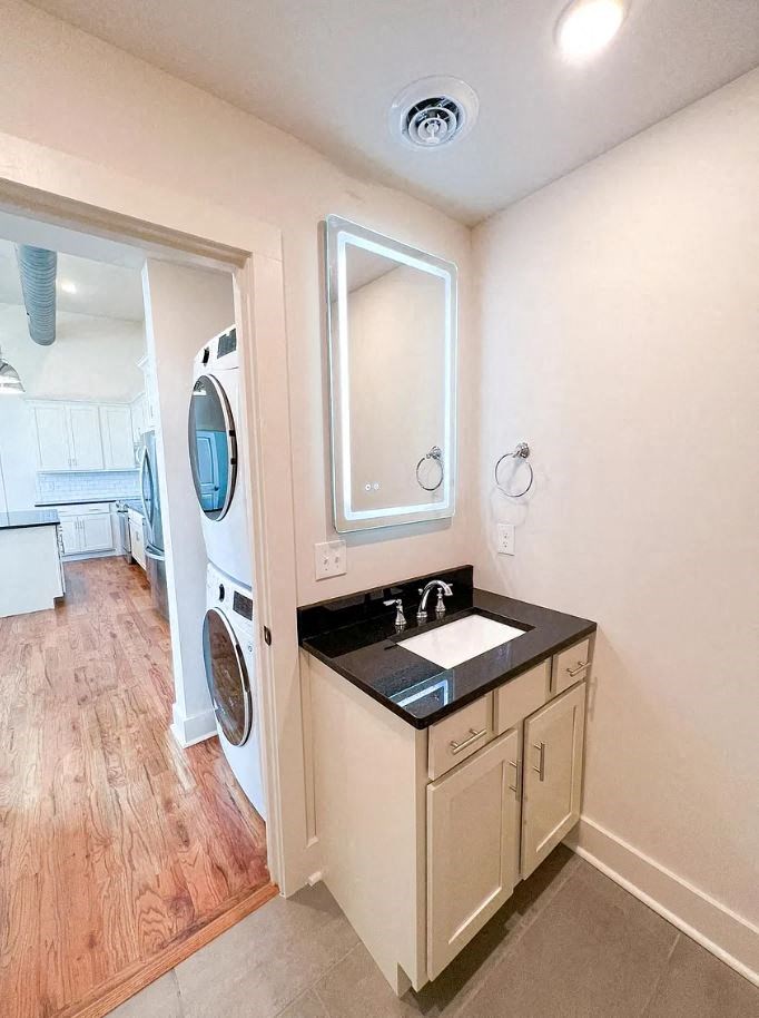 a small bathroom with a sink and a washer and dryer