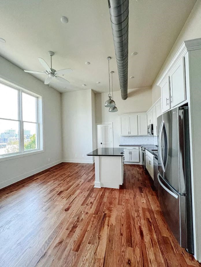 a kitchen with a center island next to a stove top oven
