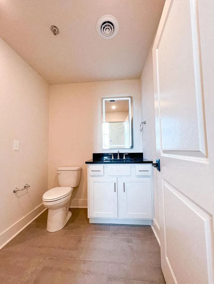 a bathroom with a toilet sink and mirror