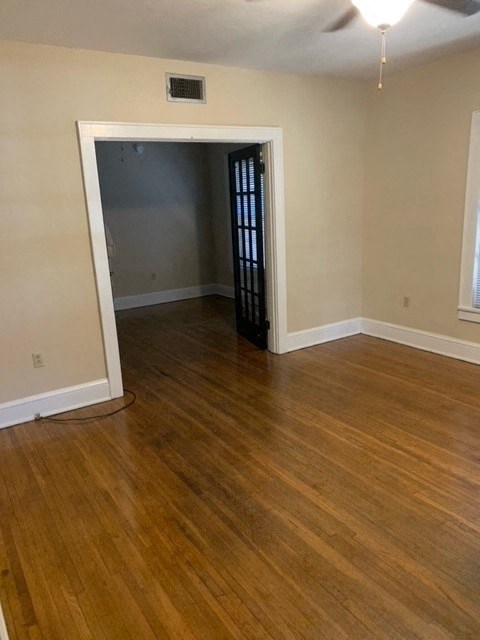 an empty living room with wood floors and a door