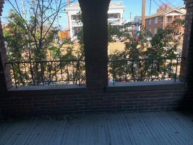 two windows on a brick wall with a wooden deck