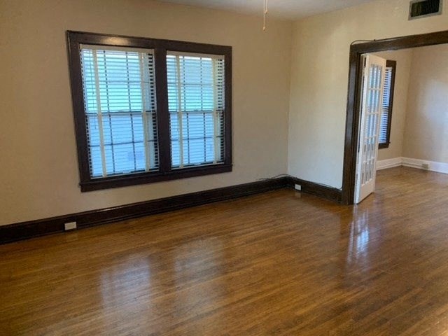 an empty living room with wood floors and windows