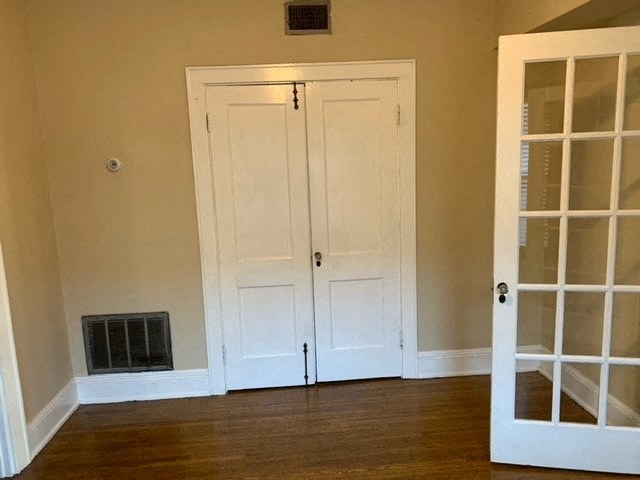 an empty room with two doors and a radiator