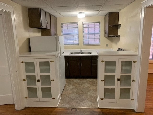 an empty kitchen with white cabinets and a sink