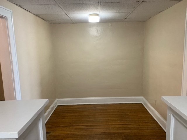 an empty room with wooden floors and a white wall
