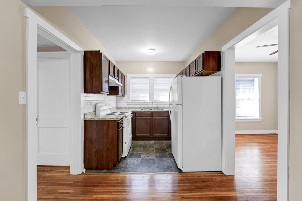 a small kitchen with white appliances and wooden cabinets